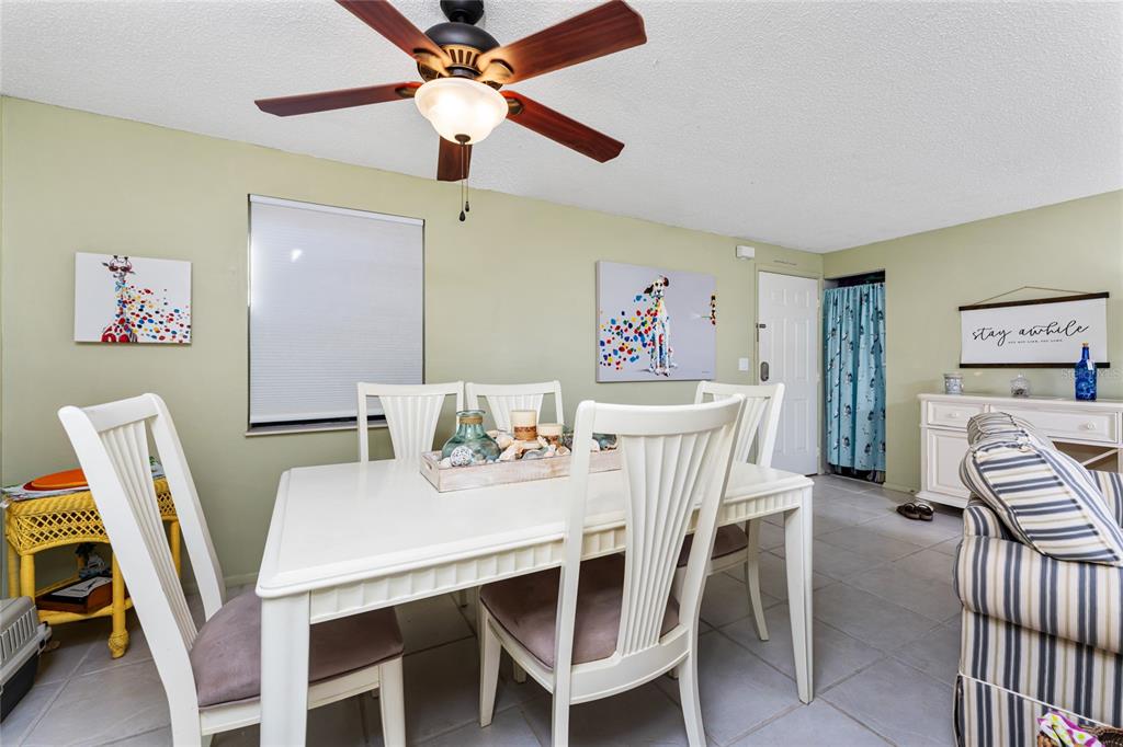 A dining room features a white table, matching chairs, a ceiling fan, and light green walls — 4022 BEAVER LANE UNIT 500C, PORT CHARLOTTE, FL