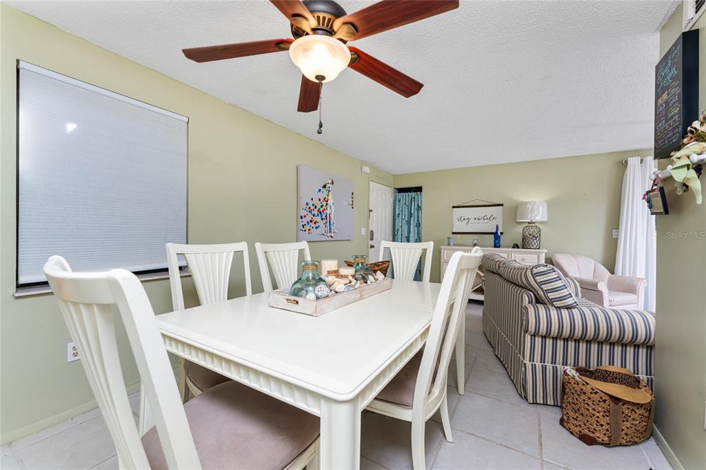 A dining area features a white table and chairs beneath a ceiling fan — 4022 BEAVER LANE UNIT 500C, PORT CHARLOTTE, FL