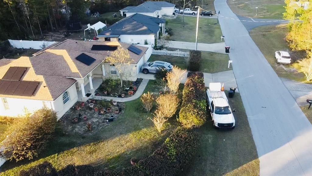 An aerial view shows a house with solar panels, a driveway, and a parked truck — 3715 SW 127TH LANE ROAD, OCALA, FL