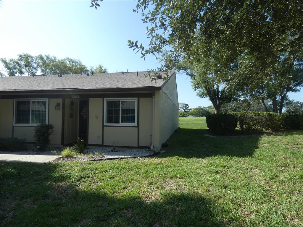 A single-story tan residential unit with a brown roof and a grassy yard — 11231 DOLLAR LAKE DRIVE UNIT 6, PORT RICHEY, FL