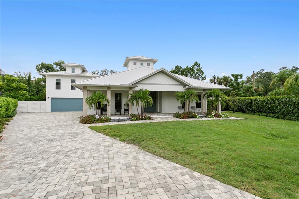 A modern house with a metal roof, paver driveway, and a two-story garage section — 1009 S MORRISON COURT, TAMPA, FL