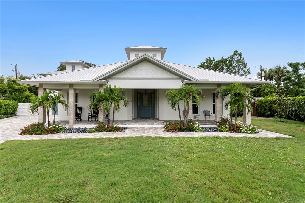 A single-story house with a metal roof, front porch, and palm trees in the yard — 1009 S MORRISON COURT, TAMPA, FL