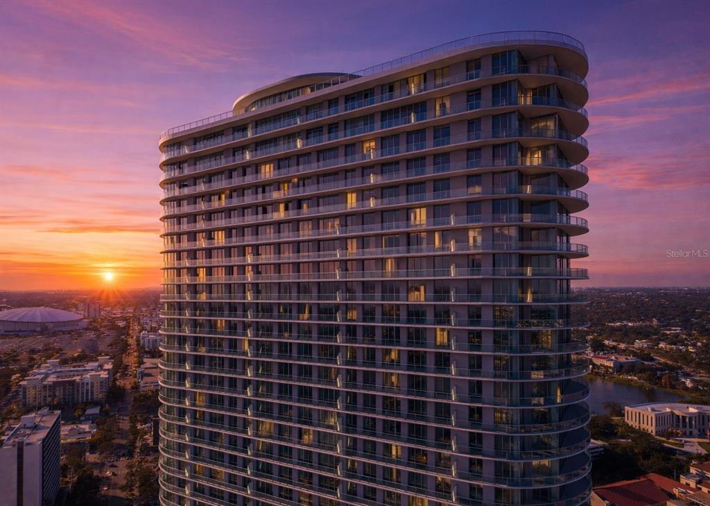 An aerial view of a modern high-rise apartment building at sunset — 400 CENTRAL AVENUE UNIT 1009, ST PETERSBURG, FL
