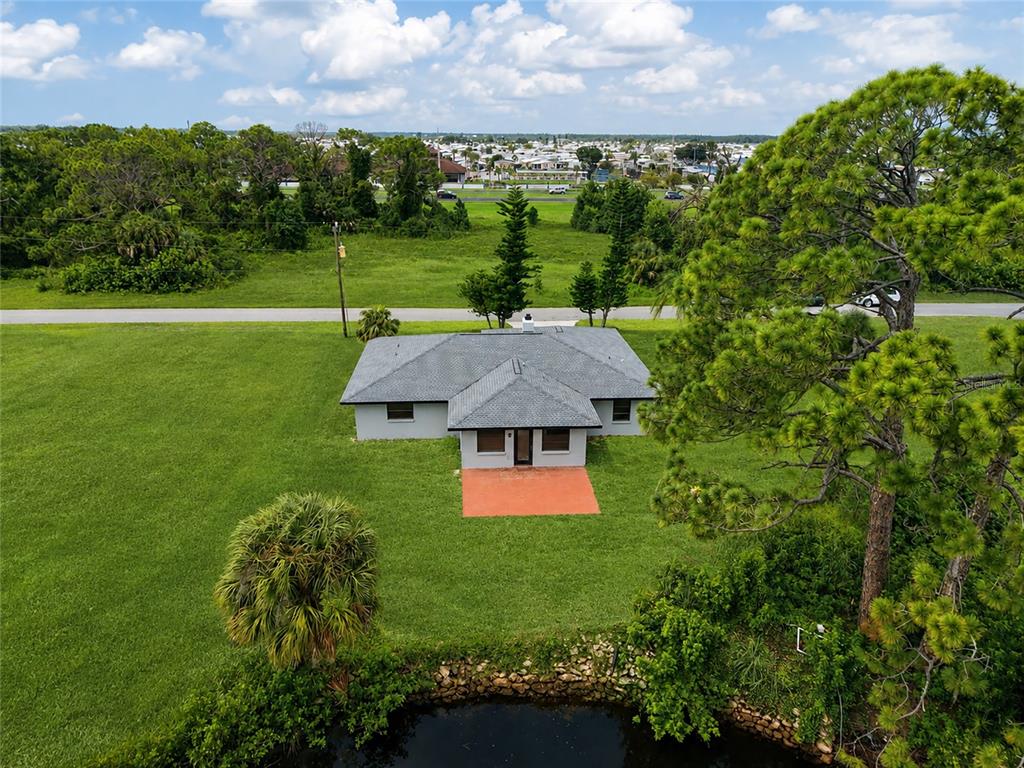 An aerial view shows a single-story house with a gray roof and orange patio — 11910 SARAGOSSA LANE, NORTH PORT, FL
