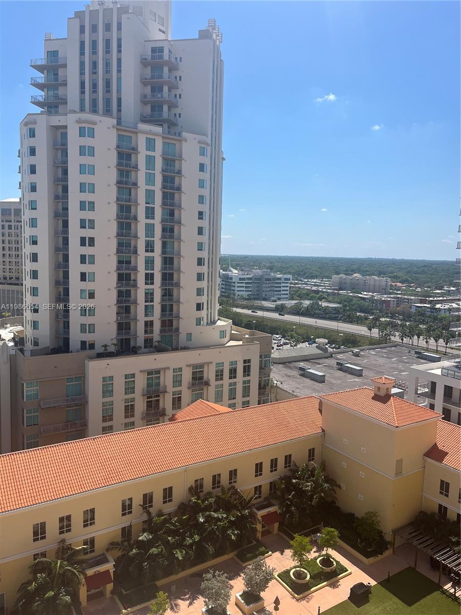 An elevated view shows a tall residential building overlooking a lower complex with terracotta roofs — 7350 SW 89th St # 1801S, Miami FL 33156, MIAMI, FL