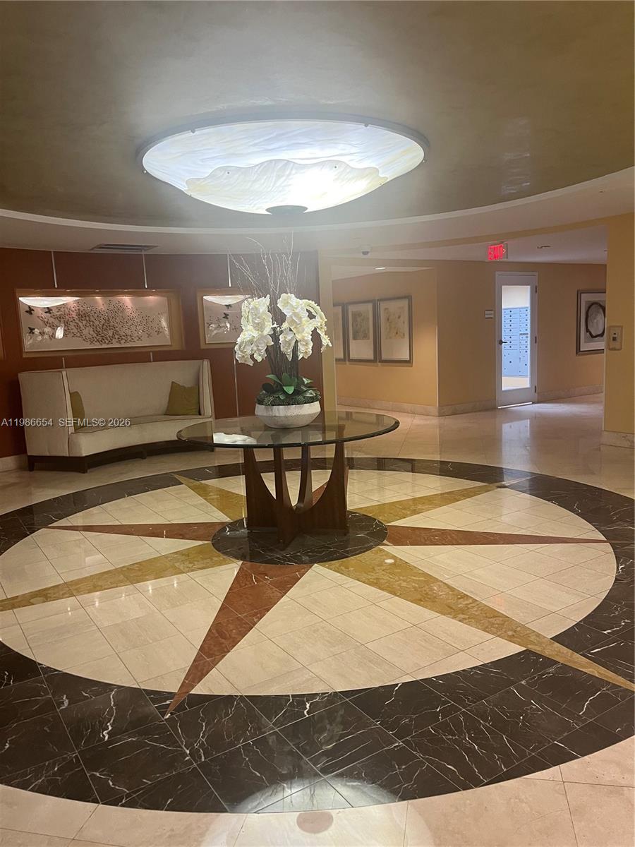 A circular lobby features a compass rose marble floor, a glass table, and white orchids — 7350 SW 89th St # 1801S, Miami FL 33156, MIAMI, FL
