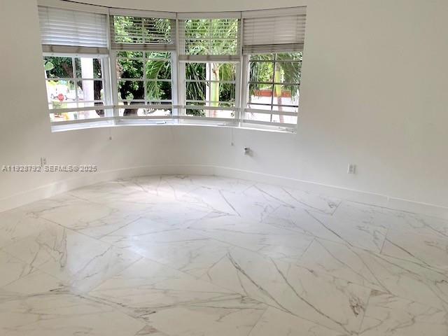 An empty room features white marble-look tile flooring and a large bay window with blinds — 1000 Meridian Ave # 23, Miami Beach FL 33139, MIAMI BEACH, FL