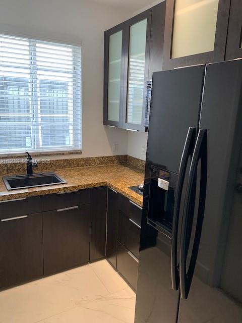 A kitchen features dark cabinetry, granite countertops, a black refrigerator, and a window with blinds — 1000 Meridian Ave # 23, Miami Beach FL 33139, MIAMI BEACH, FL