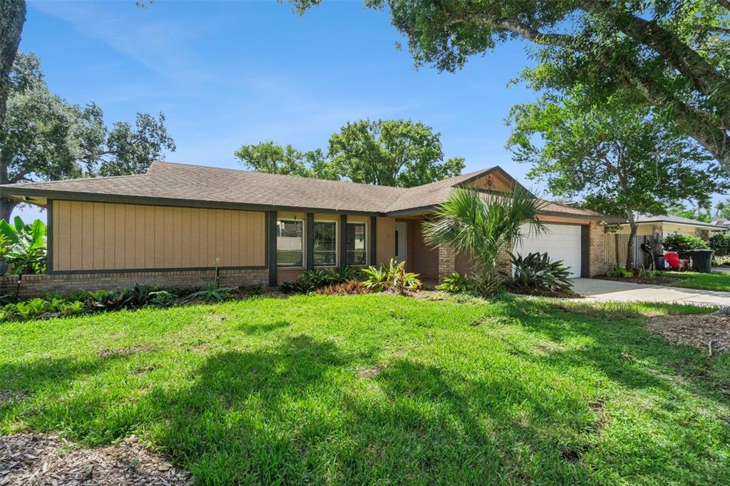 A single-story house with a brown shingled roof, vertical siding, and a two-car garage — 1591 KENLYN DRIVE, LONGWOOD, FL