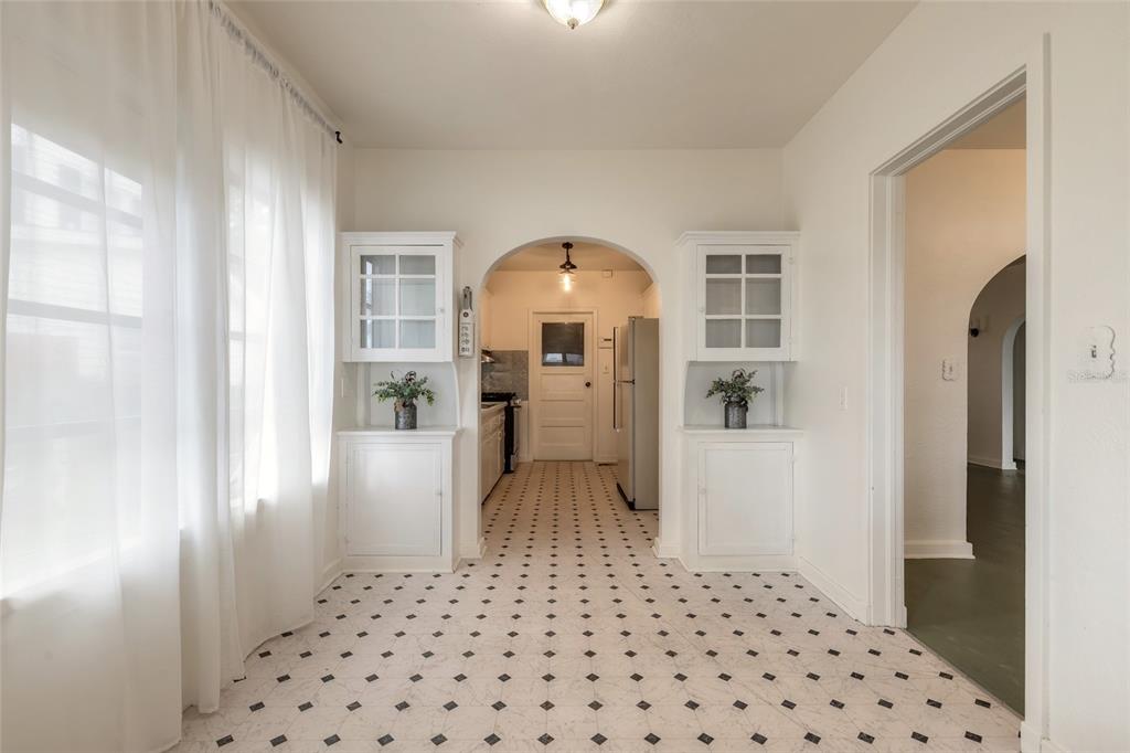 A dining room with white built-in cabinets, an arched doorway, and black-and-white tiled flooring — 255 LEXINGTON DRIVE, DAYTONA BEACH, FL