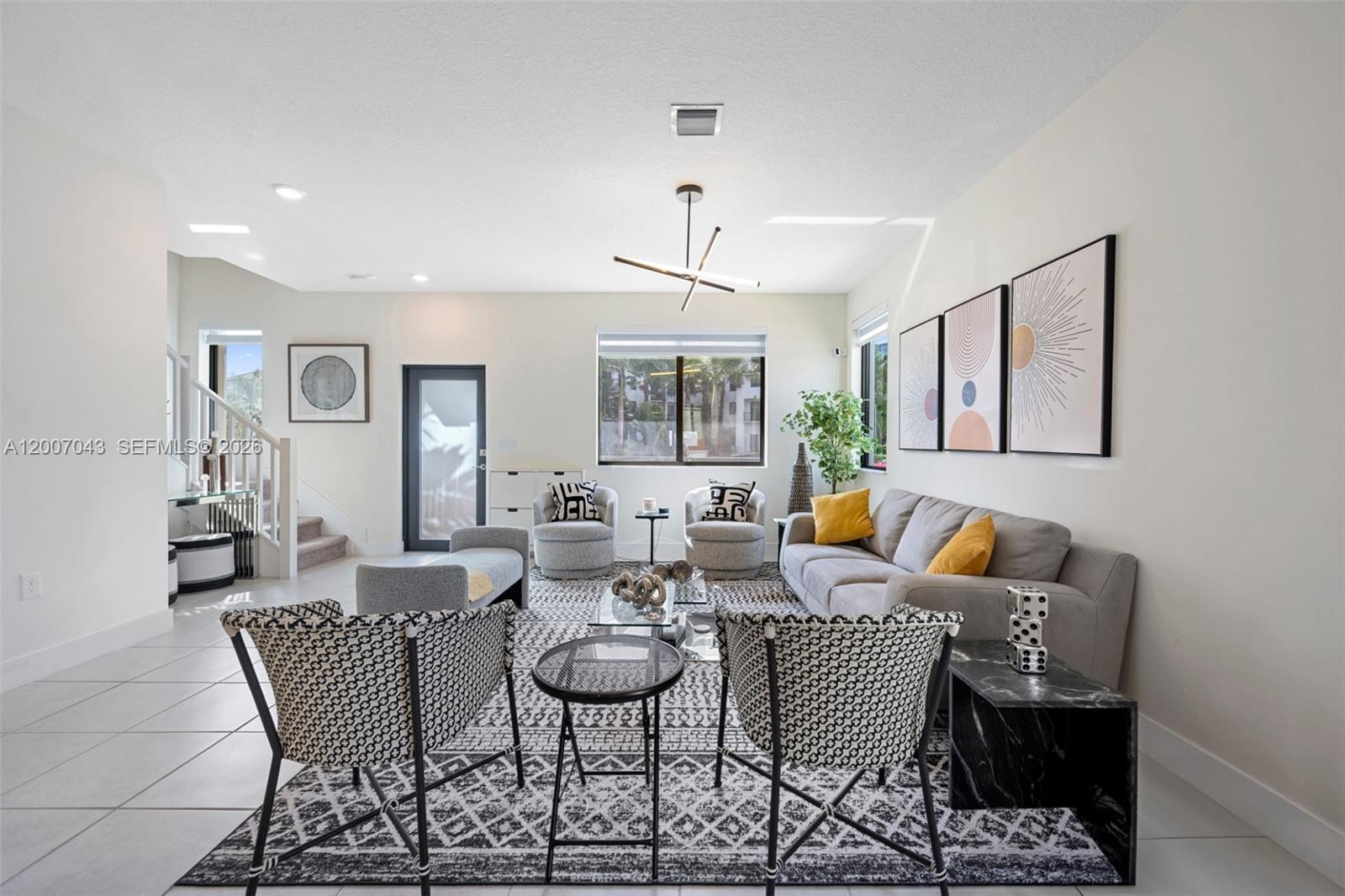 A modern living room features a grey sofa, patterned armchairs, and a large area rug — 8387 NW 43rd St, Doral FL 33166, DORAL, FL