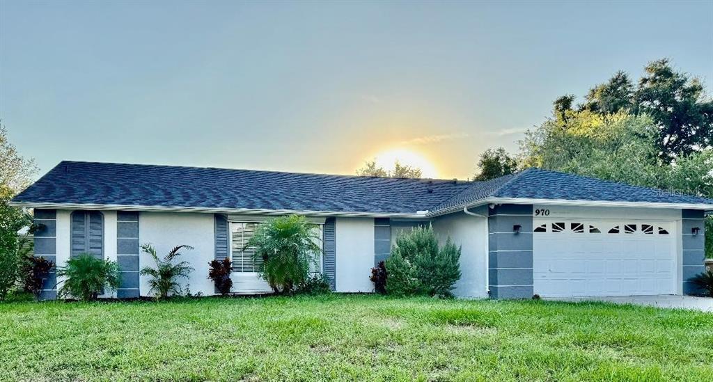 A single-story house with a white stucco exterior, blue trim, and a two-car garage — 970 AMY RIDGE COURT, KISSIMMEE, FL