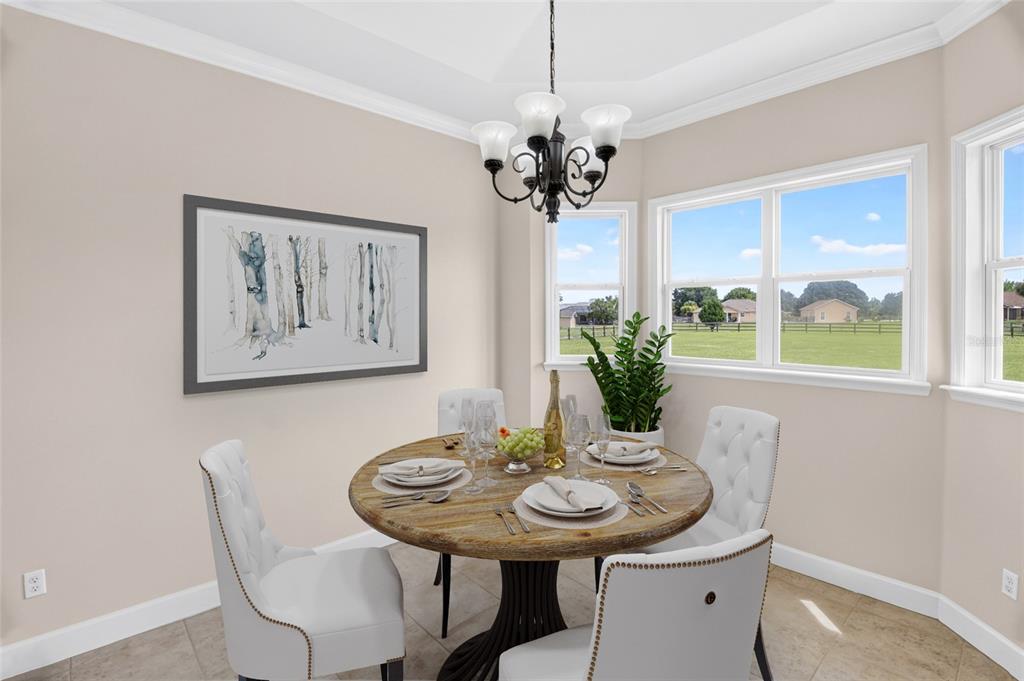 A dining area features a round wooden table, white tufted chairs, and a chandelier — 10064 SW 98TH LANE, GAINESVILLE, FL