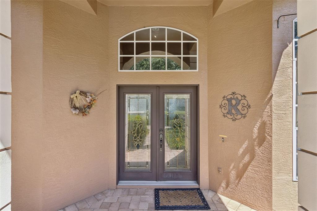 A front entryway features double glass doors with a decorative arched window above — 8041 MONIER WAY, ORLANDO, FL