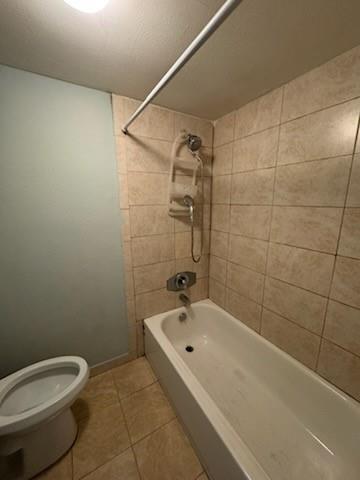 A bathroom features a white bathtub with a shower head, beige tiled walls, and a toilet — 4384 NW 9th Avenue # 2f, Pompano Beach FL 33064, POMPANO BEACH, FL