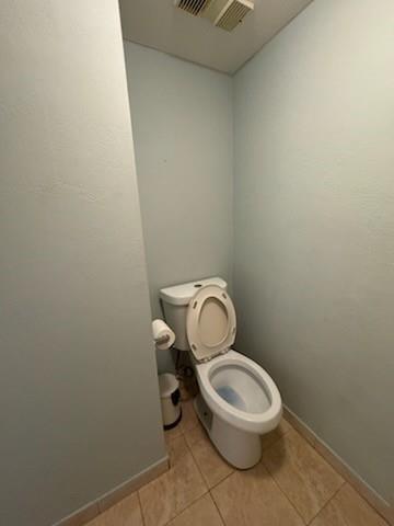 A small bathroom features a white toilet, light blue walls, and tan floor tiles — 4384 NW 9th Avenue # 2f, Pompano Beach FL 33064, POMPANO BEACH, FL