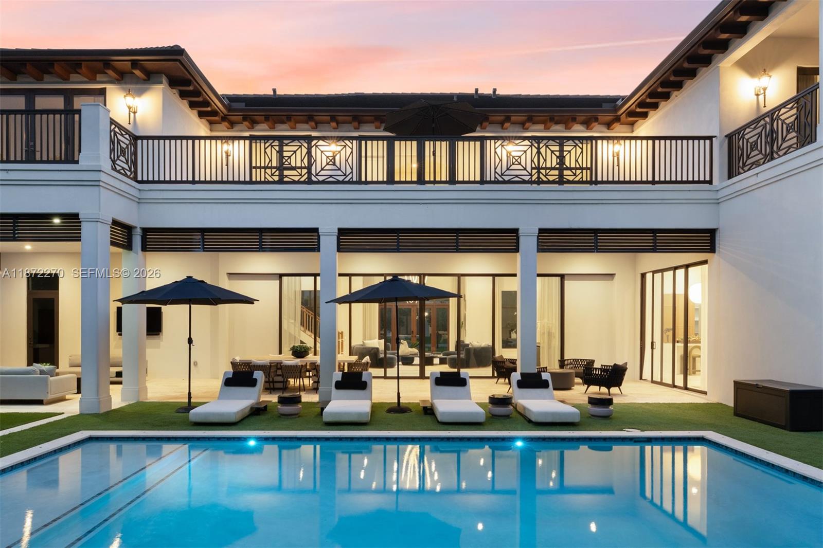A two-story white house features a swimming pool, lounge chairs, and a covered patio area — 9445 SW 72nd Ct, Pinecrest FL 33156, PINECREST, FL