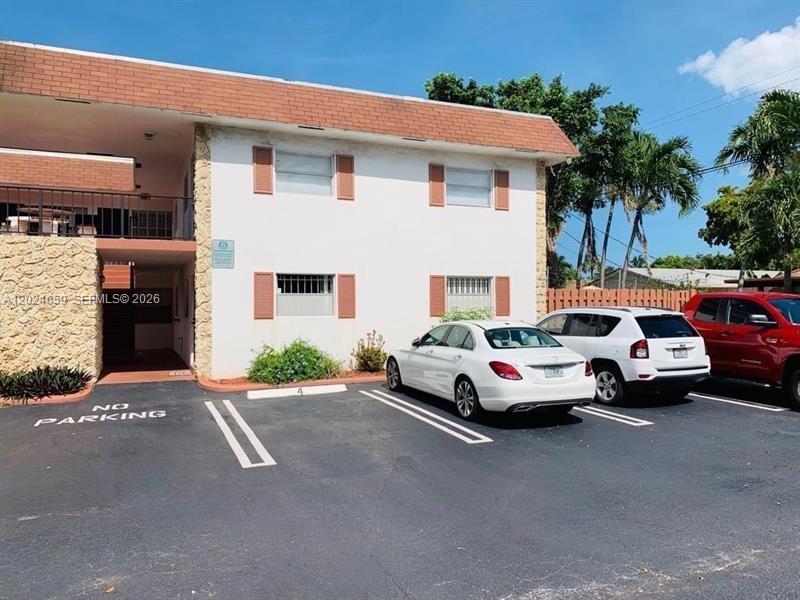 A two-story apartment building exterior with a parking lot and three parked cars — 344 SW 1st St # 9, Pompano Beach FL 33060, POMPANO BEACH, FL