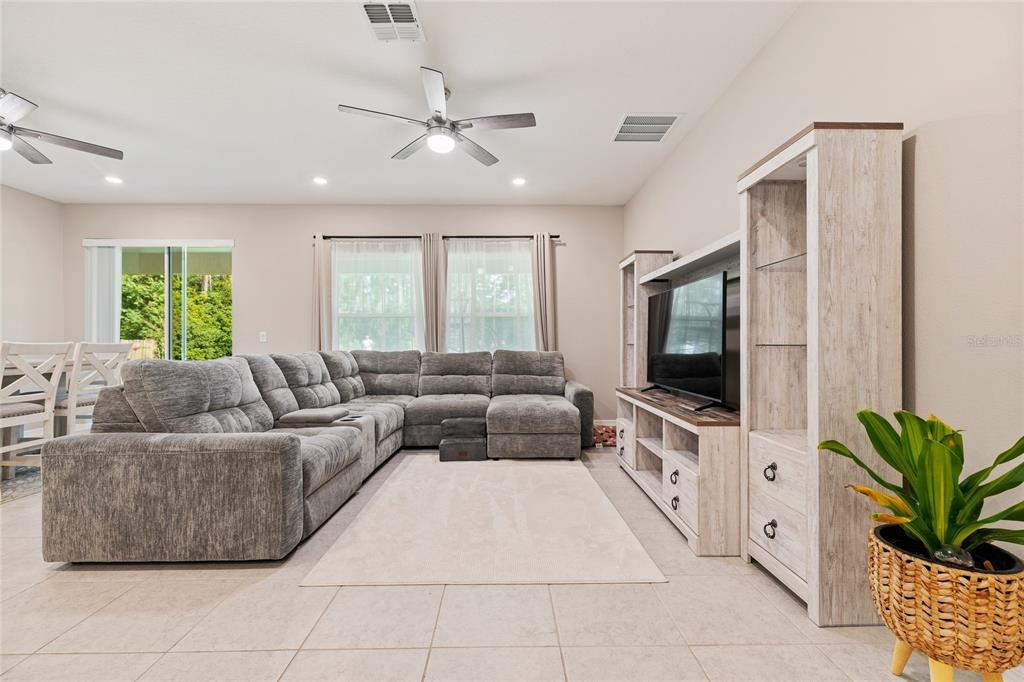 A living room features a large gray sectional sofa, a light-colored rug, and wood-toned furniture — 14 WOODWORTH DRIVE, PALM COAST, FL