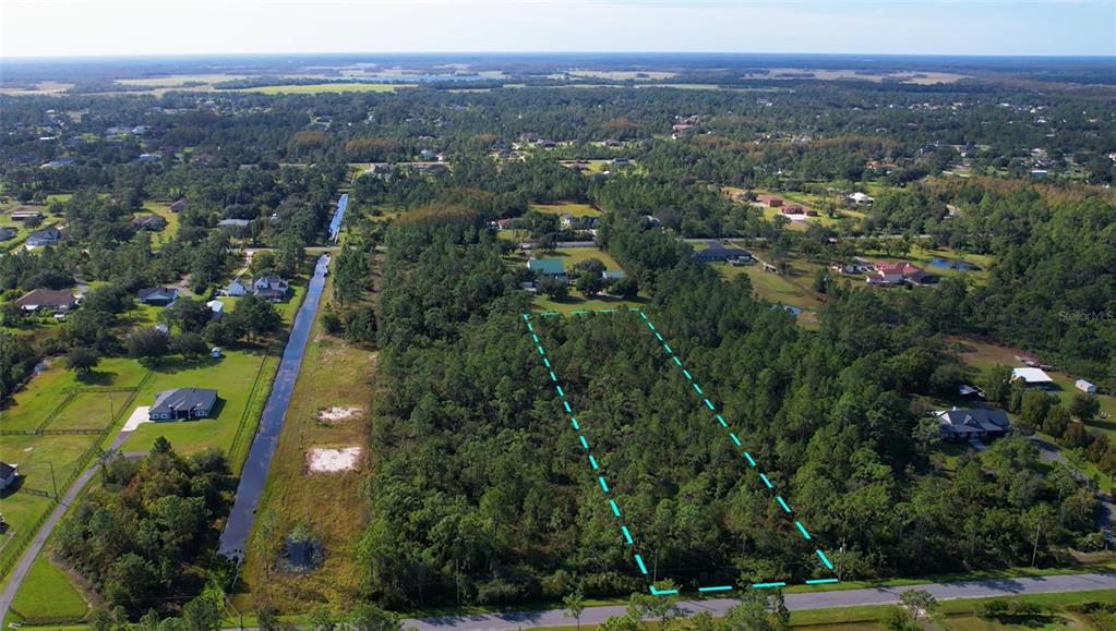 An aerial view shows a rectangular, wooded vacant lot outlined in blue along a road — Lot 531 QUINLAN STREET, ORLANDO, FL