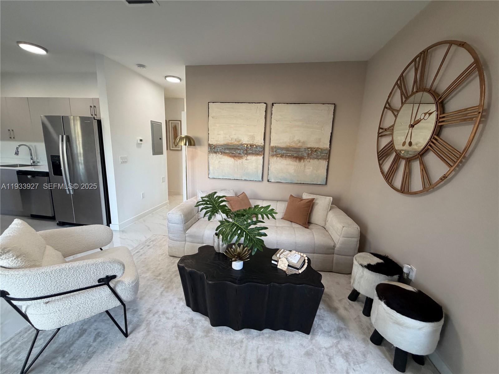 A living room features a beige sofa, a black coffee table, and a large wall clock — 2308 E 4th Ave # 205, Hialeah FL 33013, HIALEAH, FL