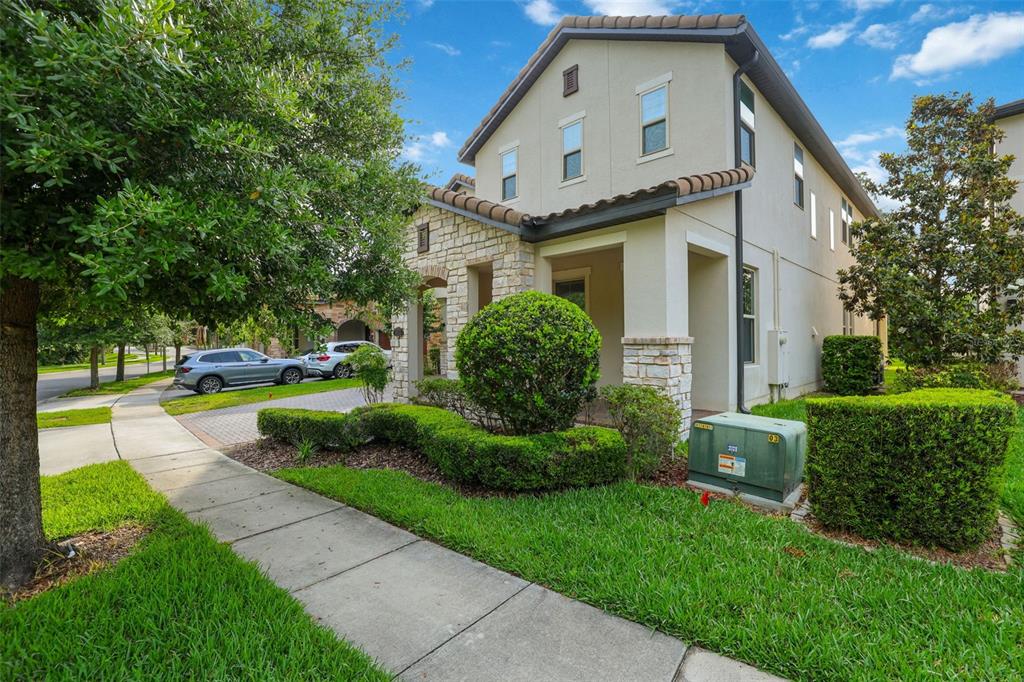 A two-story house with stone accents, a covered porch, and a landscaped front yard — 8355 TORCELLO ISLE DRIVE, WINDERMERE, FL