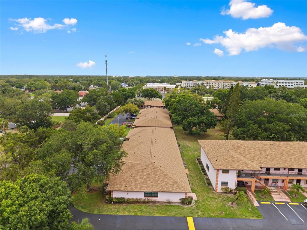 An aerial view shows two long, single-story apartment buildings with shingled roofs and parking lots — 13250 RIDGE ROAD UNIT 7-4, LARGO, FL