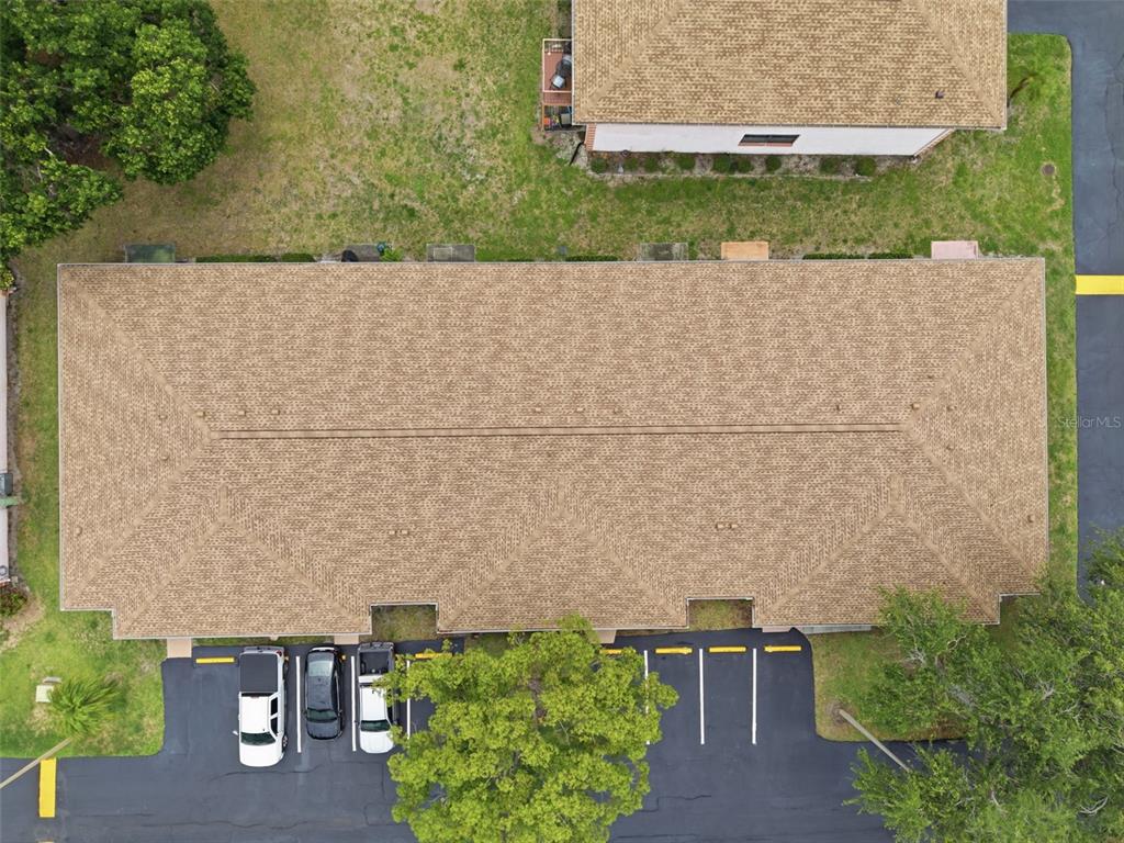 An aerial view shows a rectangular building with a shingled roof and a parking lot — 13250 RIDGE ROAD UNIT 7-4, LARGO, FL
