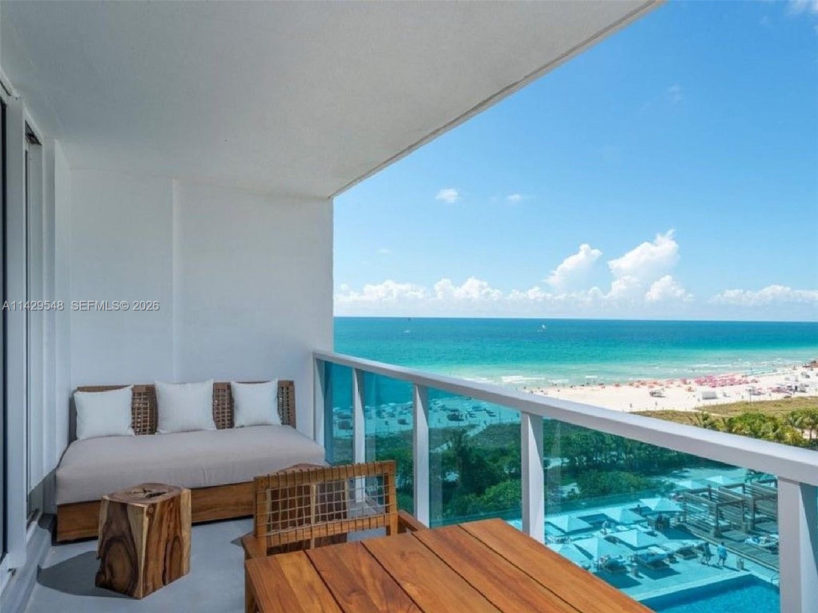 A bathroom features a tiled bathtub, a wooden vanity with a vessel sink, and a mirror — 102 24th St # 1006, Miami Beach FL 33139, MIAMI BEACH, FL