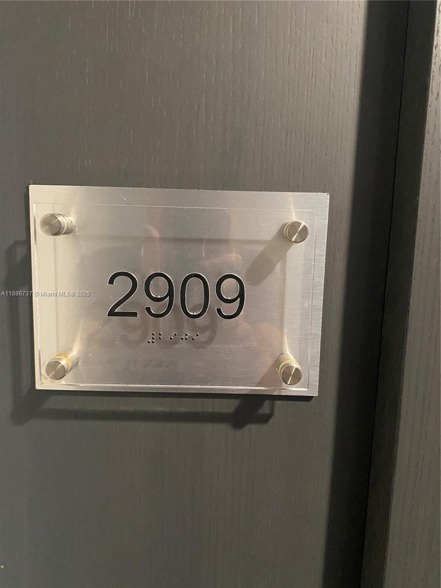A silver sign with the number 2909 and braille is mounted on a dark door — 1800 S Ocean Dr # 2909, Hallandale Beach FL 33009, HALLANDALE BEACH, FL