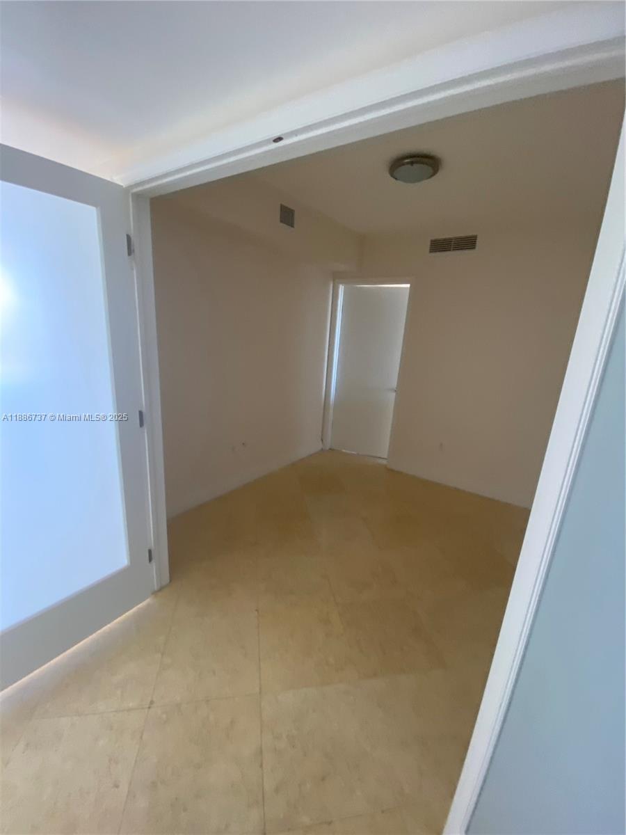 A small room with light-colored tile flooring and a white door is shown — 1800 S Ocean Dr # 2909, Hallandale Beach FL 33009, HALLANDALE BEACH, FL
