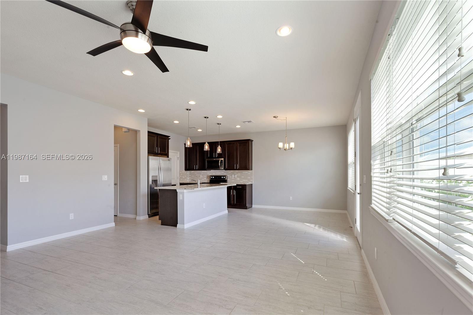 An open-concept living area features a kitchen with dark cabinetry, a dining space, and seating — 1101 Banyan Dr, Hollywood FL 33021, HOLLYWOOD, FL