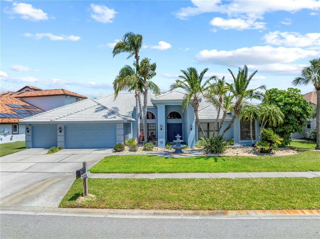 A light blue, single-story house with a white tile roof and a front yard fountain — 5104 E LONGBOAT BOULEVARD, TAMPA, FL