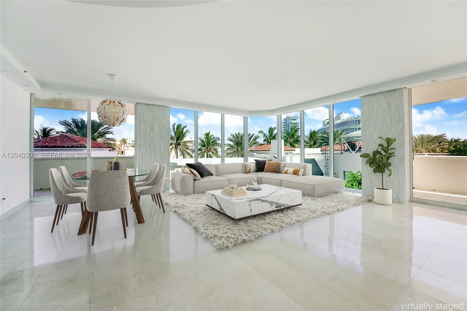 A living and dining area features floor-to-ceiling windows, marble flooring, and a marble coffee table — 300 S Pointe Dr # 405, Miami Beach FL 33139, MIAMI BEACH, FL