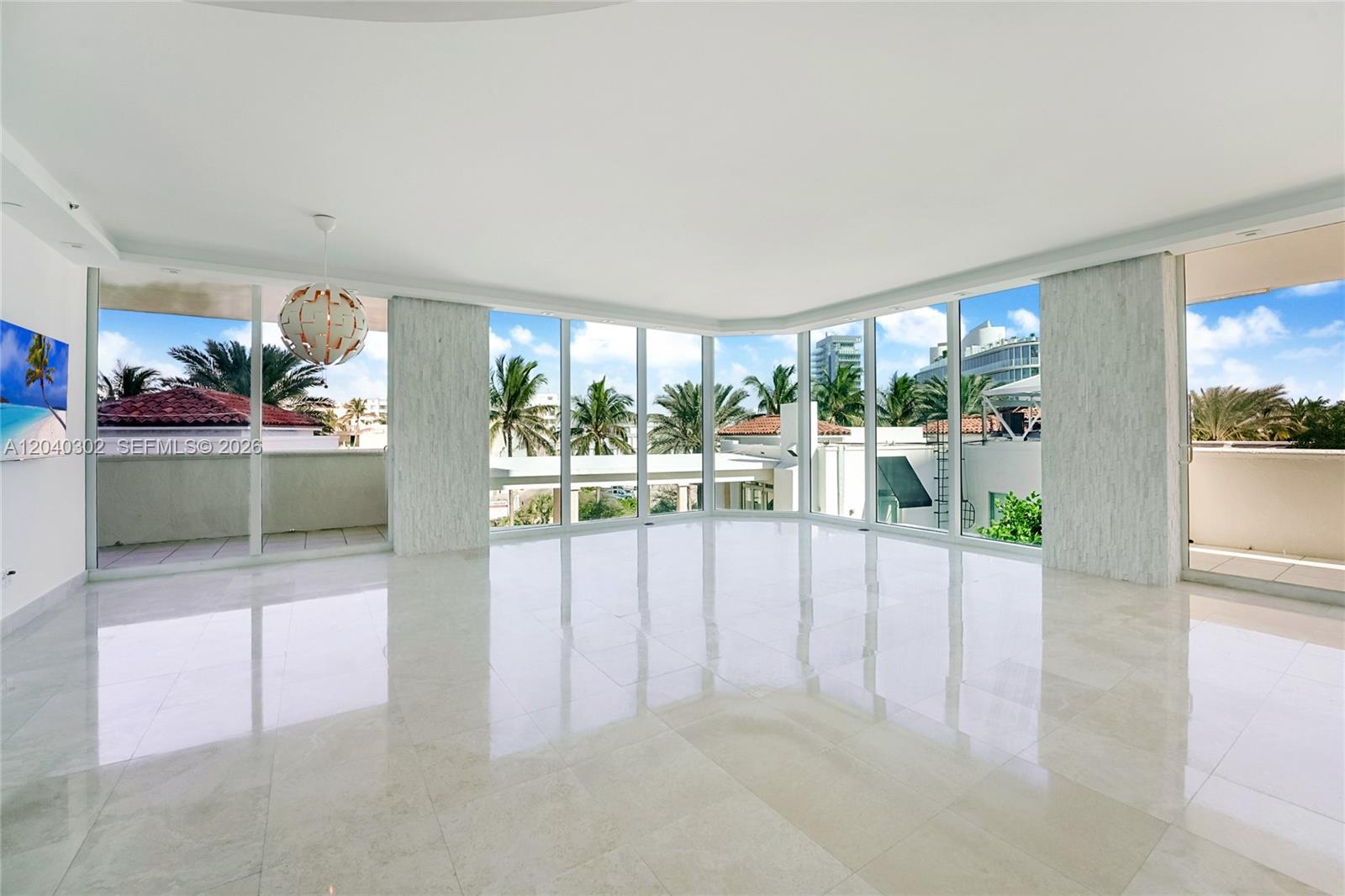 An empty room with white tile floors, floor-to-ceiling windows, and a modern pendant light — 300 S Pointe Dr # 405, Miami Beach FL 33139, MIAMI BEACH, FL