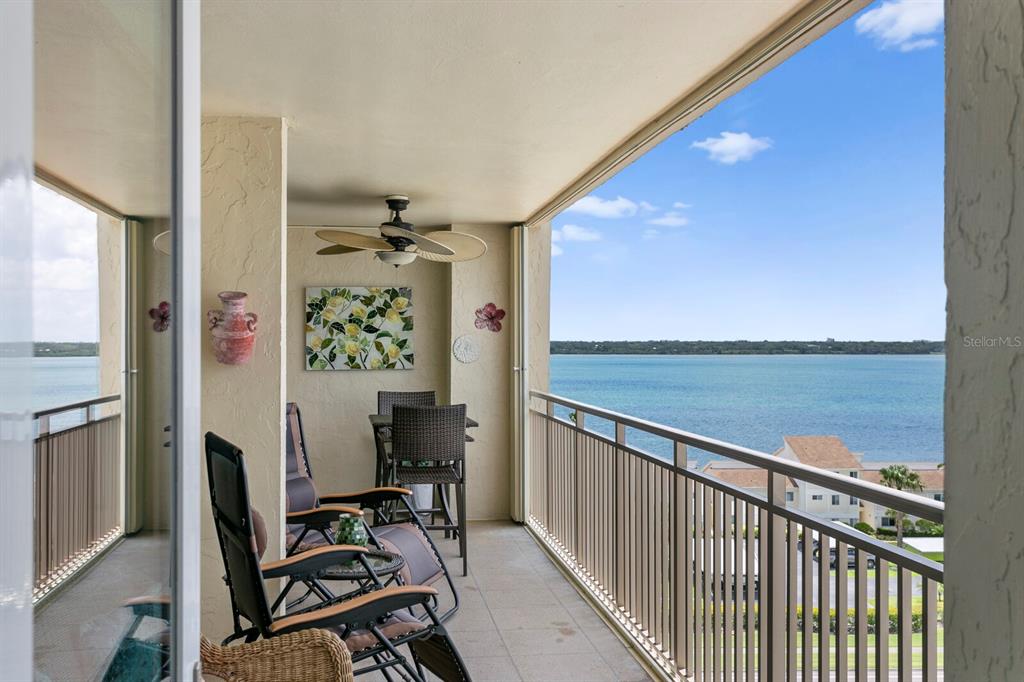 A balcony with patio furniture, a ceiling fan, and a view of the water — 1430 GULF BOULEVARD UNIT 806, CLEARWATER, FL