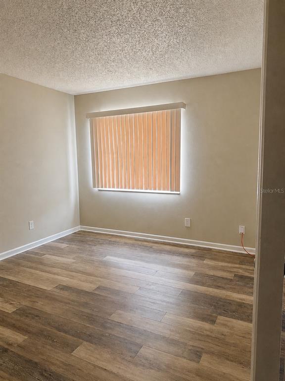 A kitchen features white cabinets, granite countertops, stainless steel appliances, and a breakfast bar — 737 MIDWAY DRIVE UNIT A, OCALA, FL