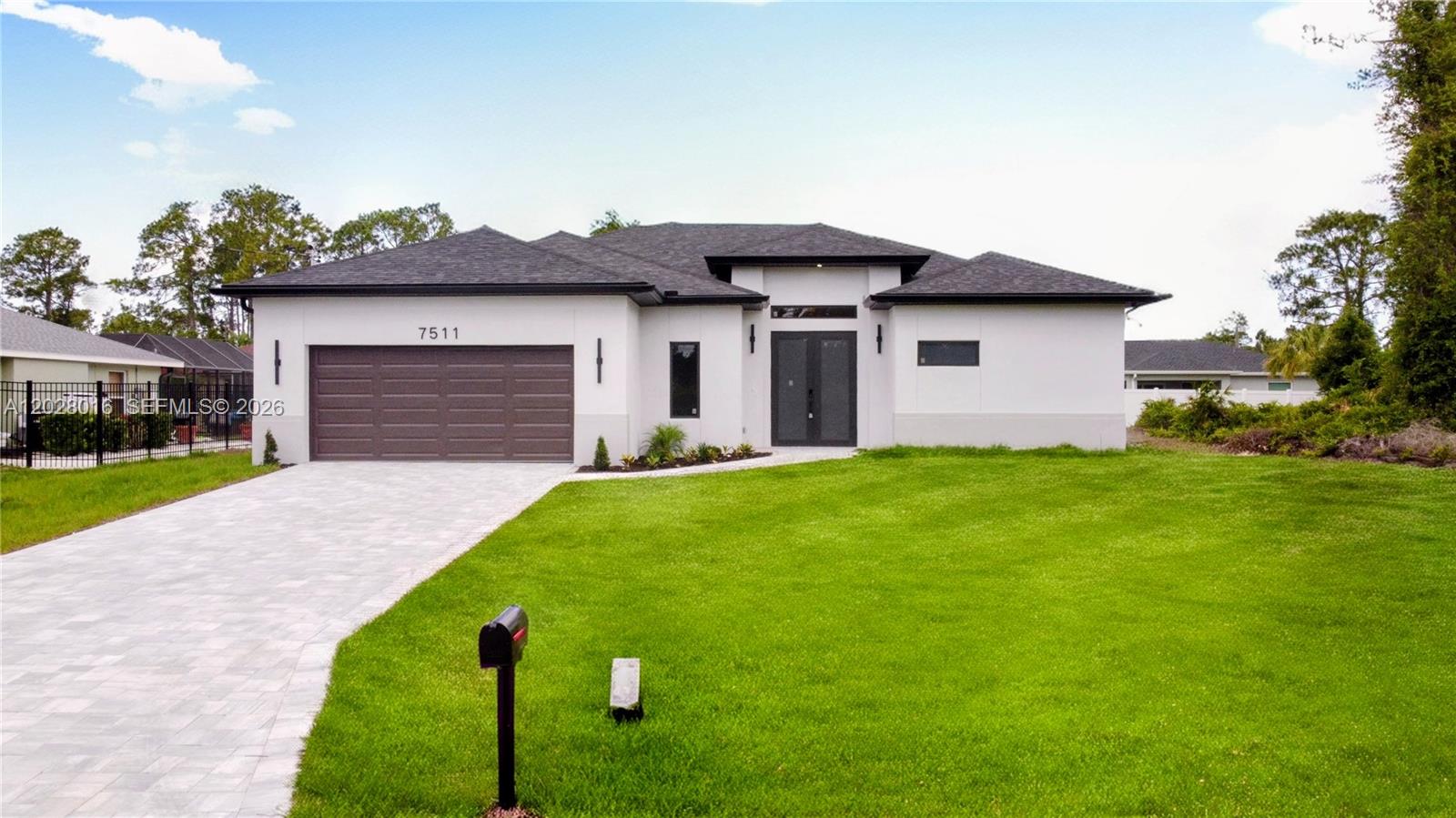 A single-story house with a white exterior, dark roof, and a paved driveway — 7511 Blutter Rd, North Port FL 34291, NORTH PORT, FL