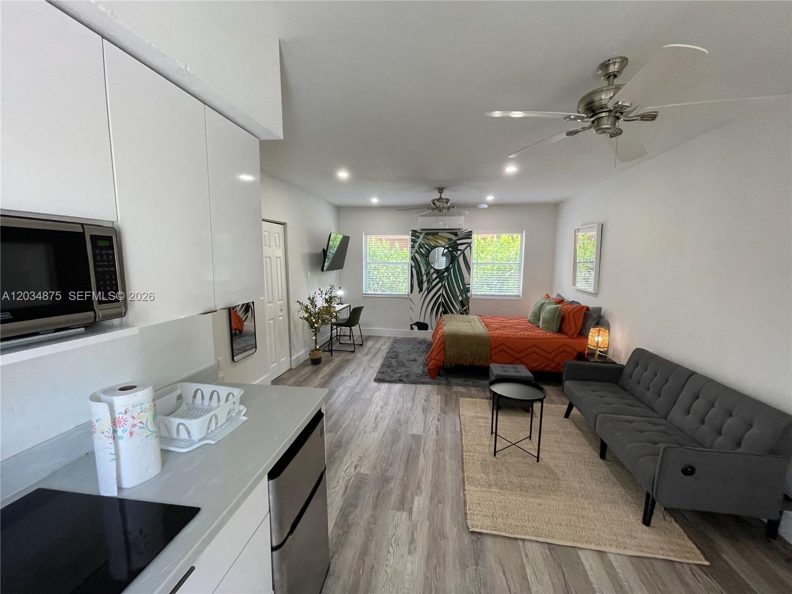 This studio apartment features a kitchen, a living area with a sofa, and a bed — MIAMI, FL