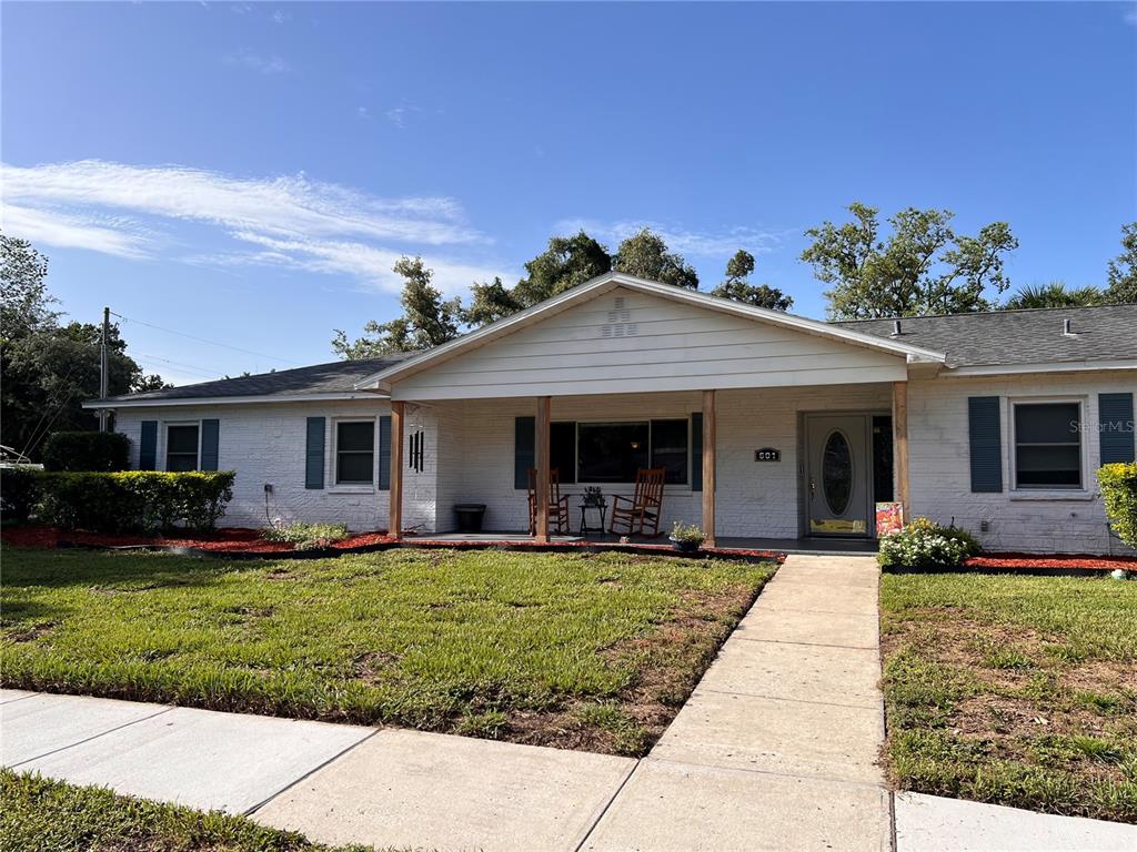 A single-story white brick house with blue shutters and a covered front porch — 601 LARRIE ELLEN WAY, BRANDON, FL