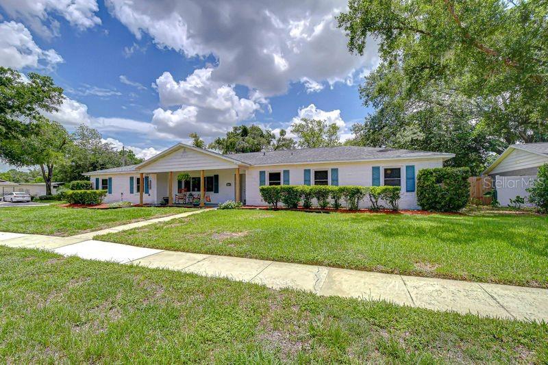 A single-story white house with blue shutters sits behind a lawn and sidewalk — 601 LARRIE ELLEN WAY, BRANDON, FL