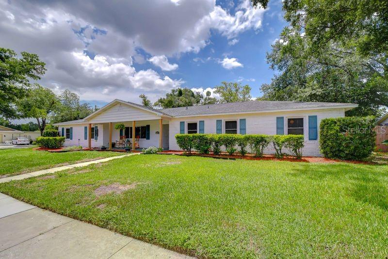 A white, single-story ranch-style house with blue shutters and a covered front porch — 601 LARRIE ELLEN WAY, BRANDON, FL