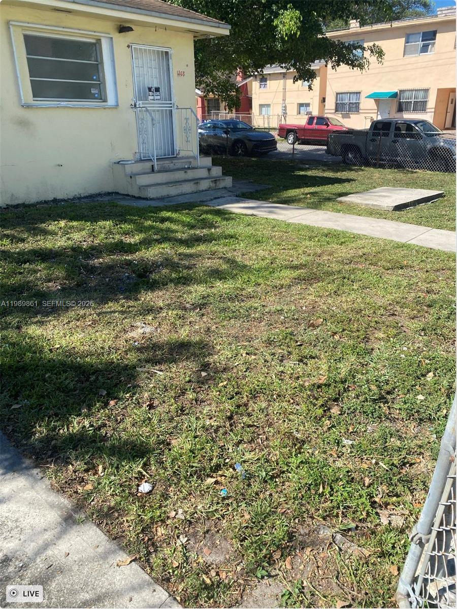 A yellow house exterior features a front door with a security gate and a lawn — 1268 SW 4th St, Miami FL 33135, MIAMI, FL