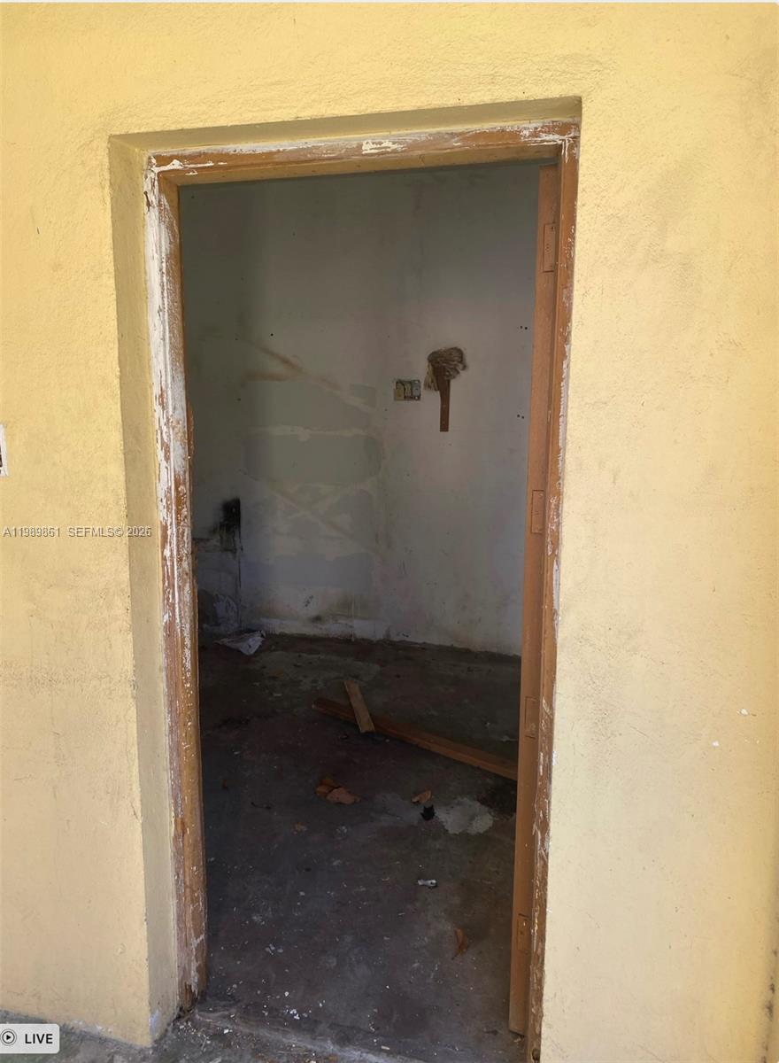 An unfinished, empty room with bare walls and a concrete floor viewed through a doorway — 1268 SW 4th St, Miami FL 33135, MIAMI, FL