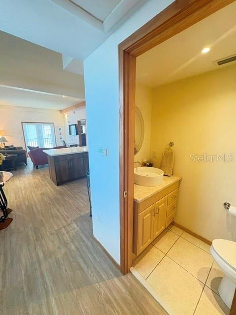 A view from a hallway into a bathroom with a vanity and a living area — 101 PALM HARBOR PARKWAY UNIT B225, PALM COAST, FL