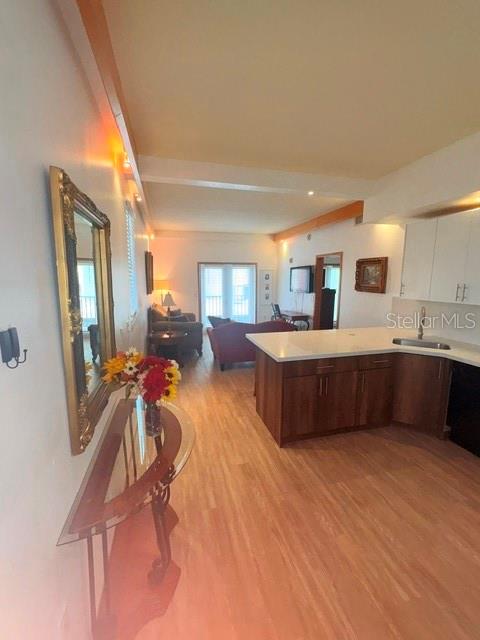 An open-concept kitchen with wood cabinets and an island overlooks a living area with flooring — 101 PALM HARBOR PARKWAY UNIT B225, PALM COAST, FL
