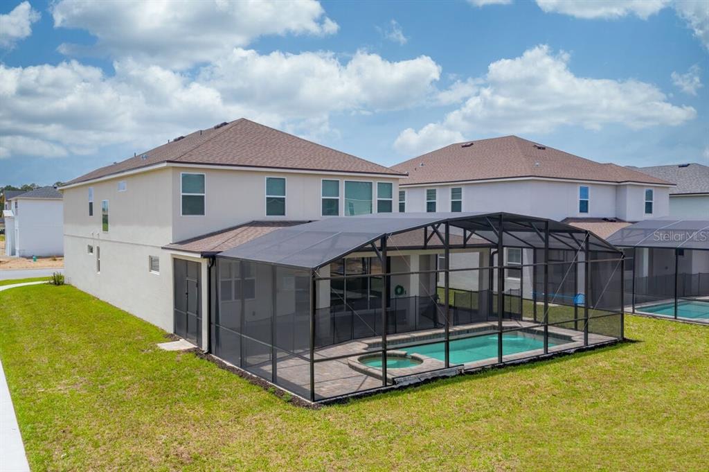 A two-story house with a screened-in pool and spa in the backyard — 8951 HILTON RIDGE AVENUE, KISSIMMEE, FL