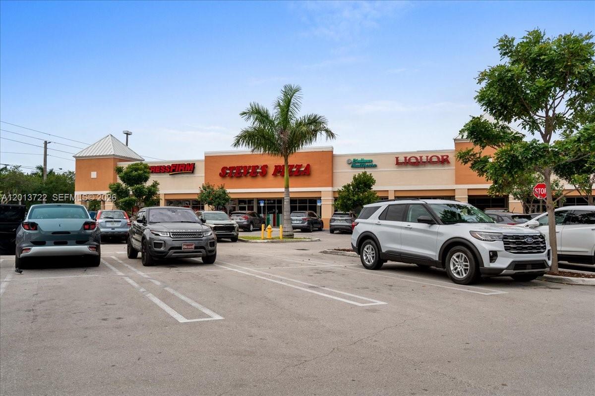 The exterior of a commercial strip mall features storefronts including Steve's Pizza and a liquor store — 16285 SW 88 ST, Kendall FL 33193, KENDALL, FL