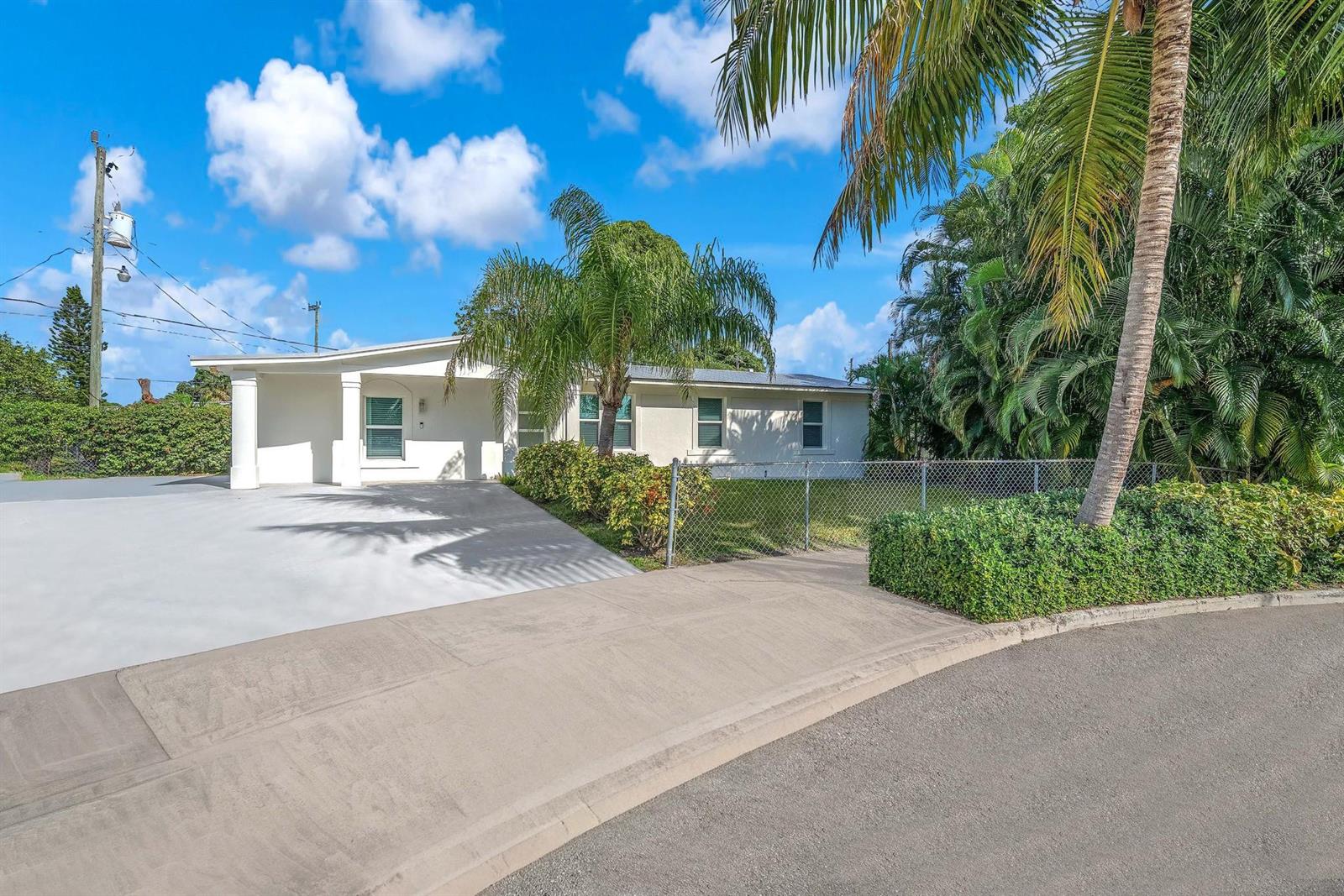 A single-story house with a white exterior, a concrete driveway, and palm trees — 3308 E El Vedado Court, West Palm Beach FL 33405, WEST PALM BEACH, FL