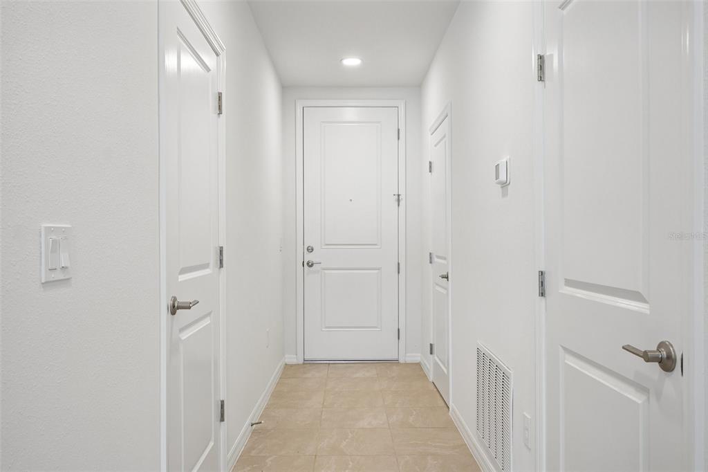 A bright entryway features a tiled floor, white walls, and several white interior doors — 34559 TURPINS AVENUE, ZEPHYRHILLS, FL
